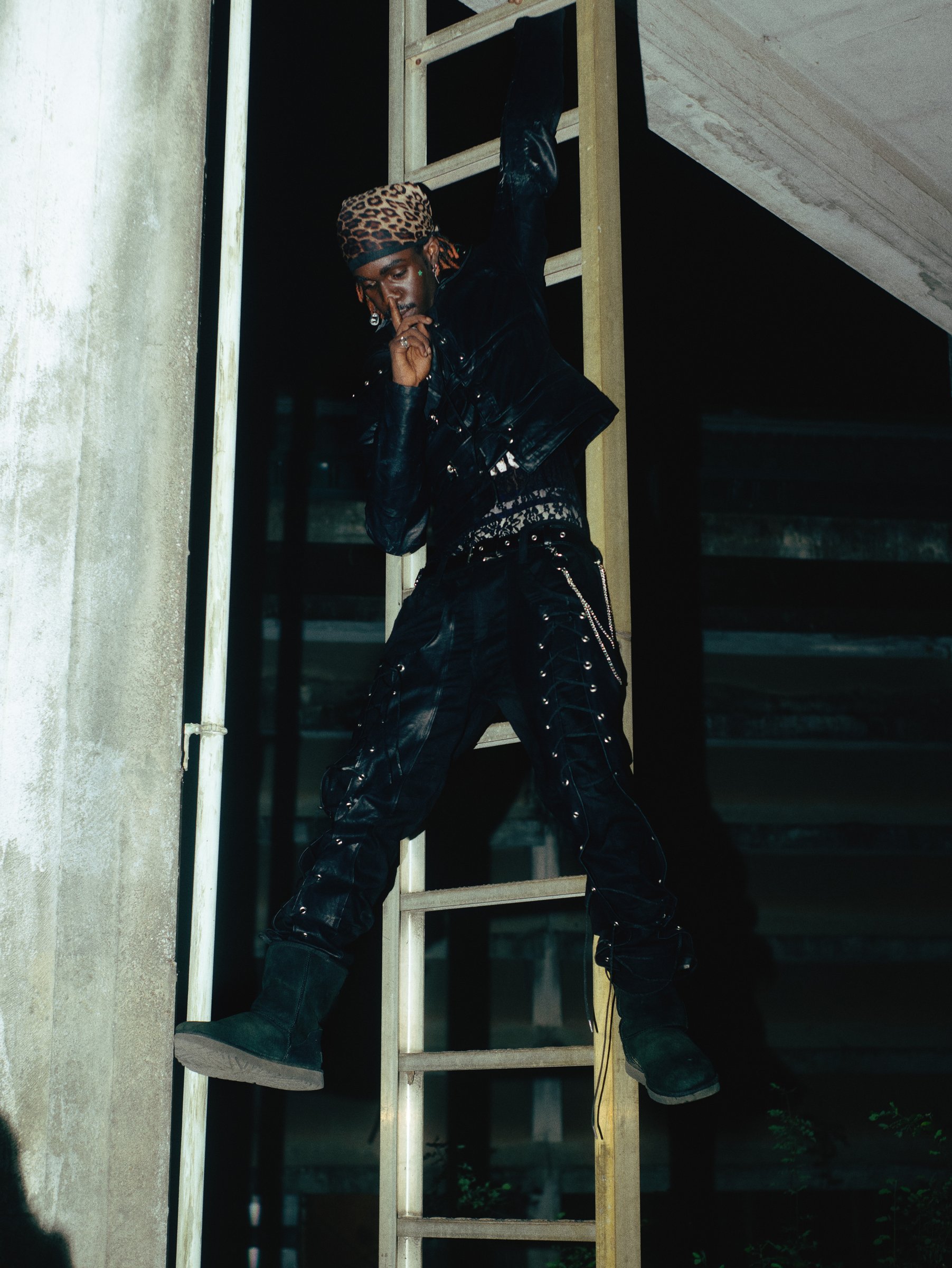 Model in black lace-up pants, mid-motion